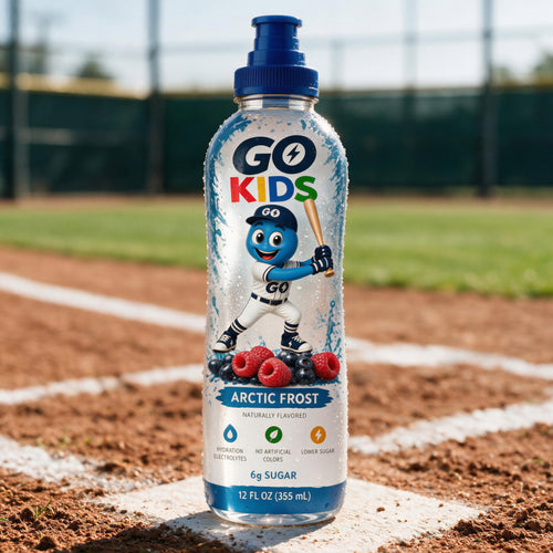 A bottle of GO KIDS Arctic Frost drink placed on green grass in front of a soccer goal, with the product centered and the brand name clearly visible on the label.